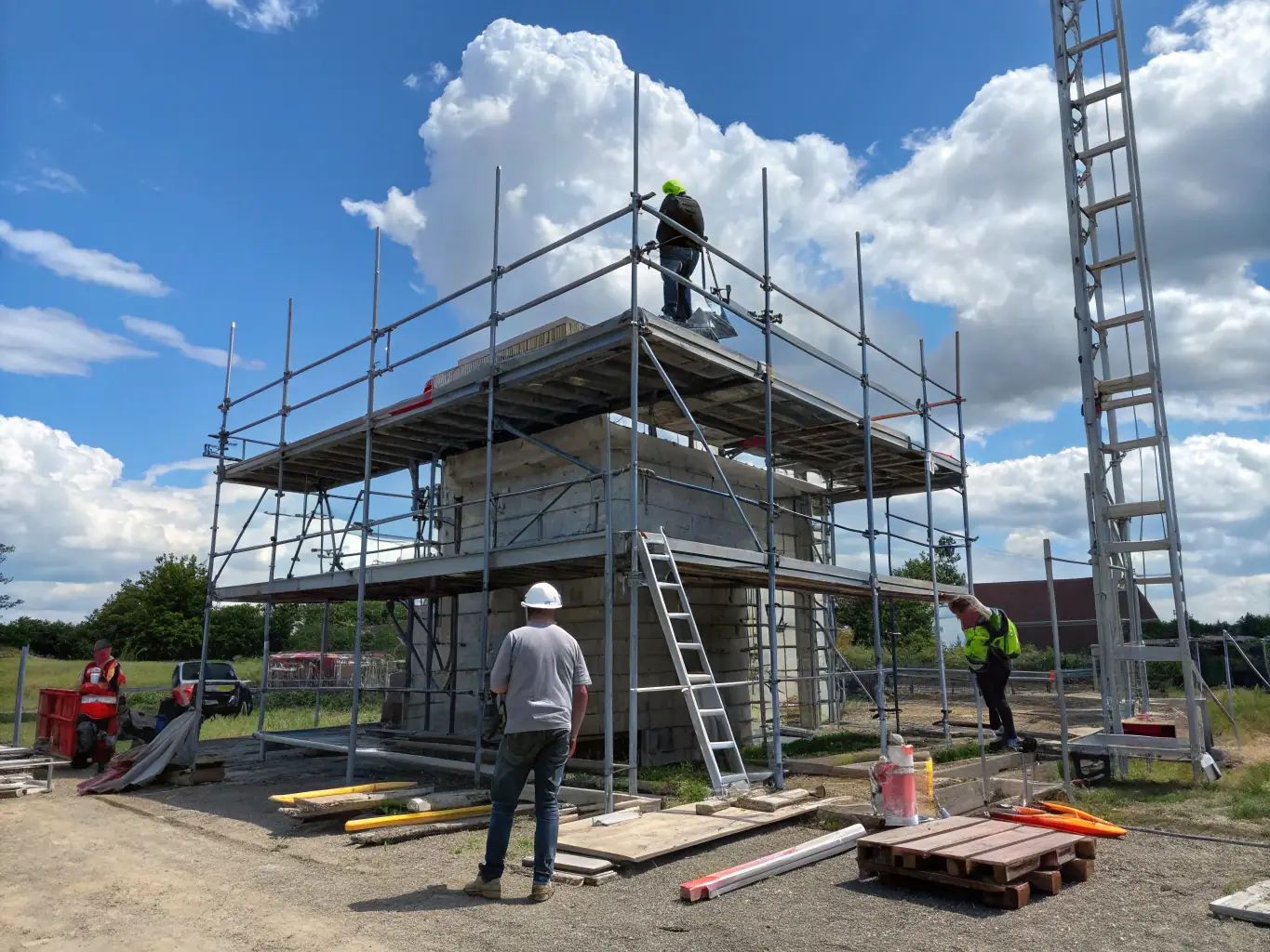 A high-angle shot of Maqtec's aluminum scaffolding system erected around a building under construction, showcasing its lightweight and modular design.